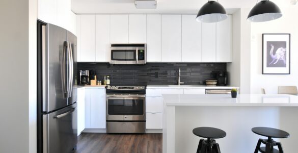 a kitchen with white cabinets and a black stool