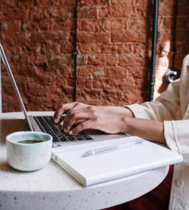 person in white long sleeve shirt using macbook pro