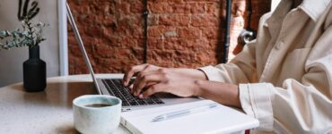 person in white long sleeve shirt using macbook pro