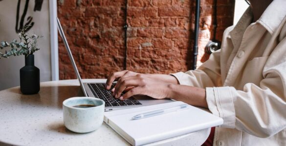 person in white long sleeve shirt using macbook pro