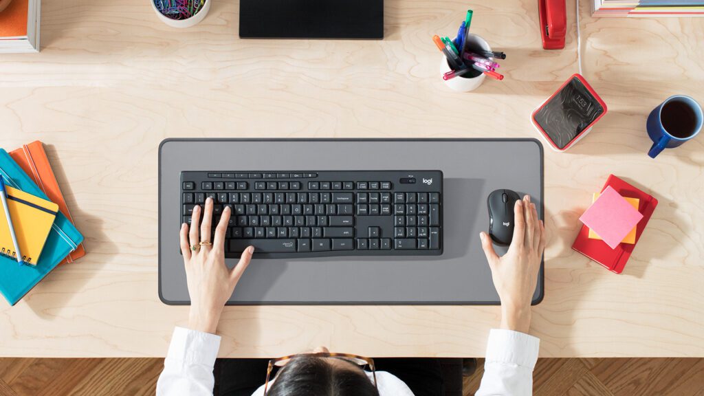 Vista superior de un teclado y ratón inalámbricos en un espacio de trabajo organizado