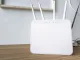 Router WiFi moderno de doble banda con cuatro antenas externas omnidireccionales sobre una superficie de madera.