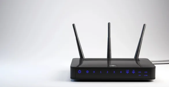 Cómo funciona Internet en tu casa: Guía técnica completa del ISP a tu dispositivo 86 Router WiFi negro con tres antenas externas, LEDs indicadores de puertos LAN, USB y bandas 2.4G y 5G sobre fondo gris neutro