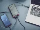 Power bank cargando dos móviles por USB-C junto a un portátil sobre la mesa