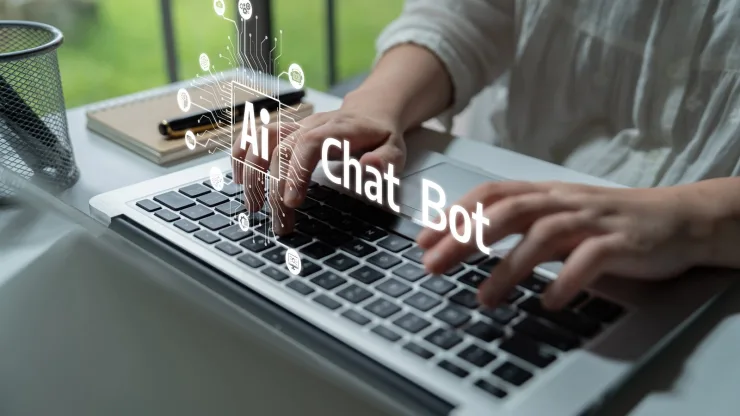 Manos escribiendo en un portátil con iconos de chatbot de IA superpuestos, como al crear Gemini Skills