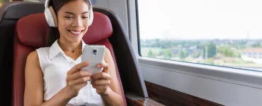 Persona usando auriculares con cancelación de ruido en transporte público durante el teletrabajo