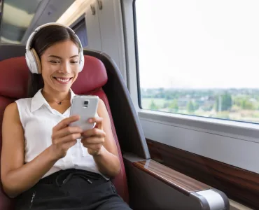 Persona usando auriculares con cancelación de ruido en transporte público durante el teletrabajo