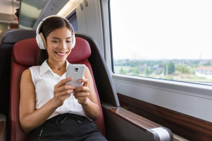 Persona usando auriculares con cancelación de ruido en transporte público durante el teletrabajo