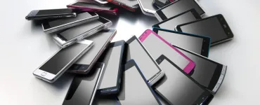 Varios smartphones de distintos colores colocados en círculo sobre una superficie gris
