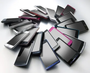 Varios smartphones de distintos colores colocados en círculo sobre una superficie gris