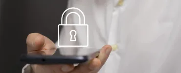 Controles parentales WhatsApp para adolescentes: qué son y cómo activarlos 77 Mano adulta sosteniendo un smartphone con icono de candado, metáfora de privacidad y controles parentales en WhatsApp