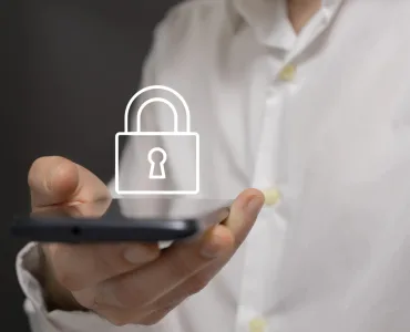 Controles parentales WhatsApp para adolescentes: qué son y cómo activarlos 76 Mano adulta sosteniendo un smartphone con icono de candado, metáfora de privacidad y controles parentales en WhatsApp