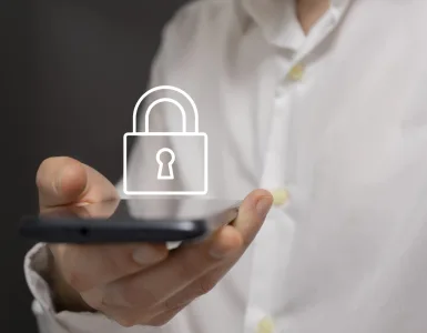 Mano adulta sosteniendo un smartphone con icono de candado, metáfora de privacidad y controles parentales en WhatsApp