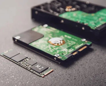 Comparativa visual de un SSD de estado sólido y un disco duro HDD sobre un escritorio de teletrabajo