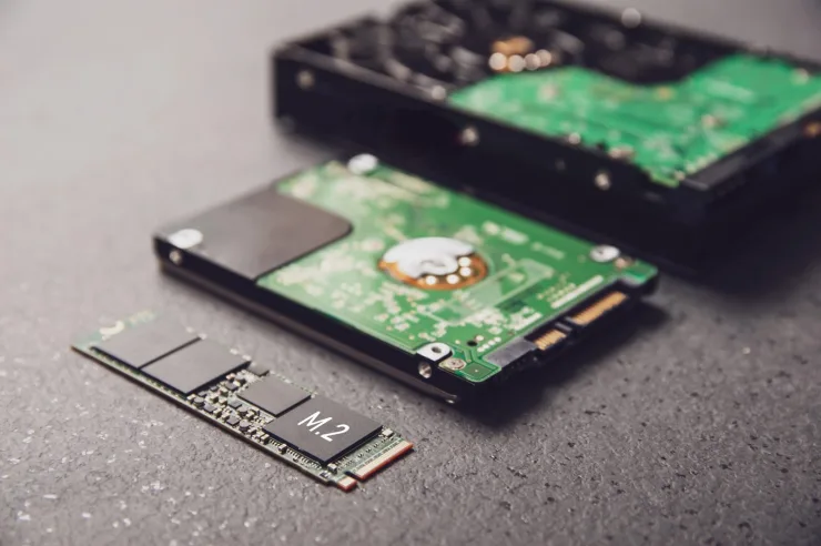 Comparativa visual de un SSD de estado sólido y un disco duro HDD sobre un escritorio de teletrabajo